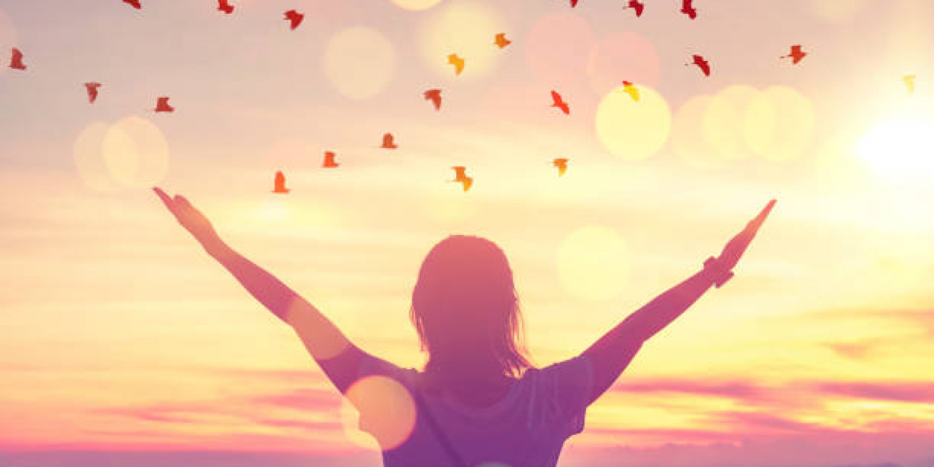 Freedom feel good and travel adventure concept. Copy space of silhouette woman rising hands on sunset sky at top of mountain and bird fly abstract background. Vintage tone filter effect color style.